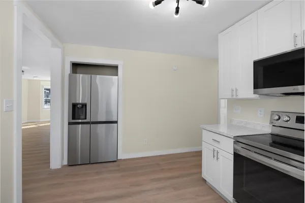 a kitchen with a refrigerator and a stove top oven