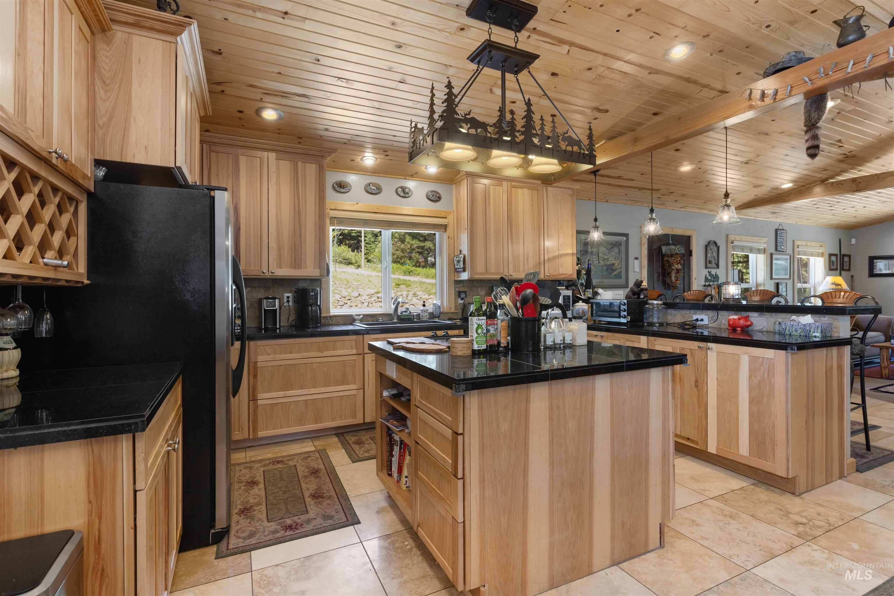1 Miller Lane Cascade, ID 83611 - Photo 12 of 39 Kitchen featuring light brown cabinets, wooden ceiling, a center island, a peninsula, and tasteful backsplash