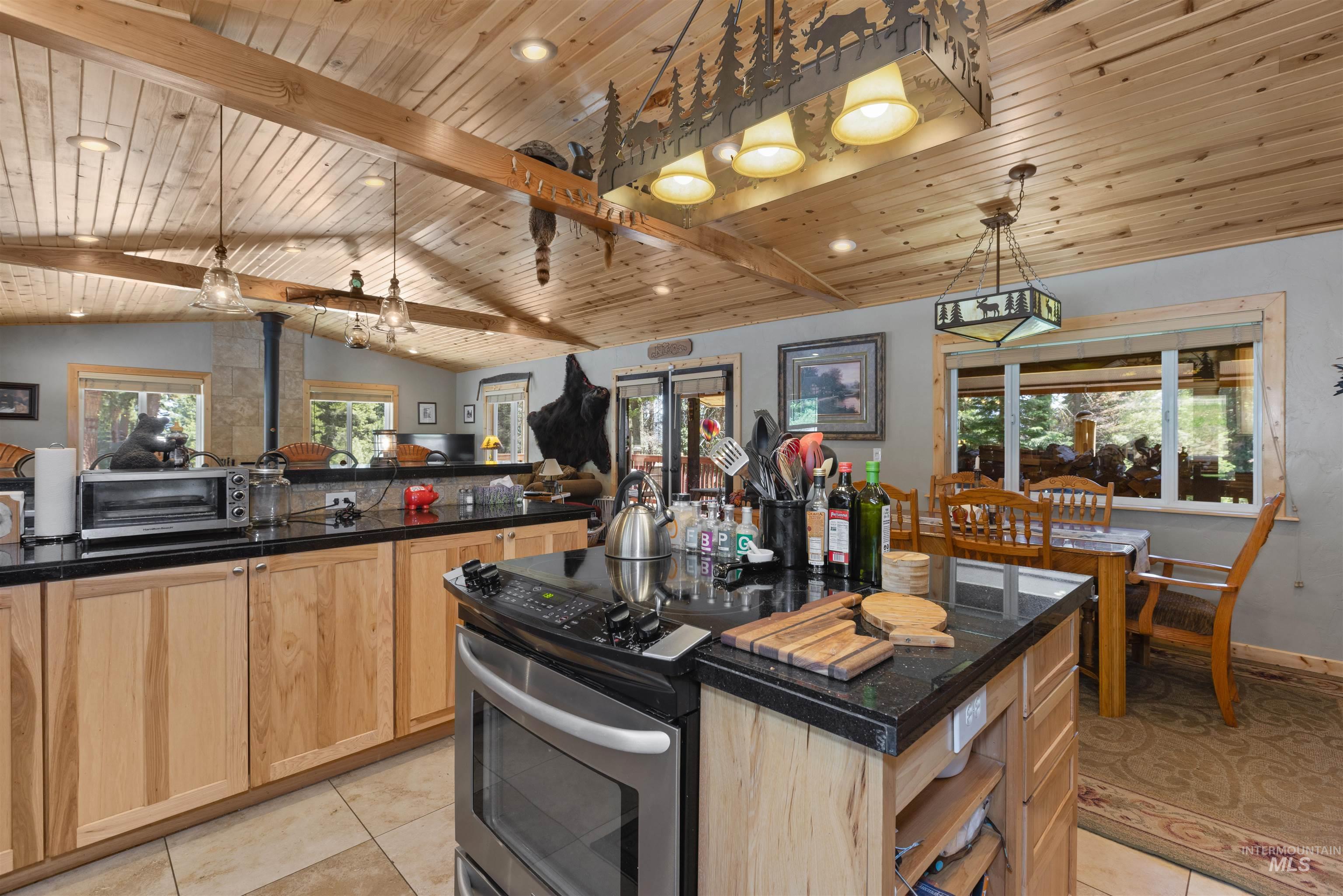 1 Miller Lane Cascade, ID 83611 - Photo 14 of 39 Kitchen featuring light brown cabinets, stainless steel range with electric stovetop, light tile patterned flooring, wooden ceiling, and dark countertops