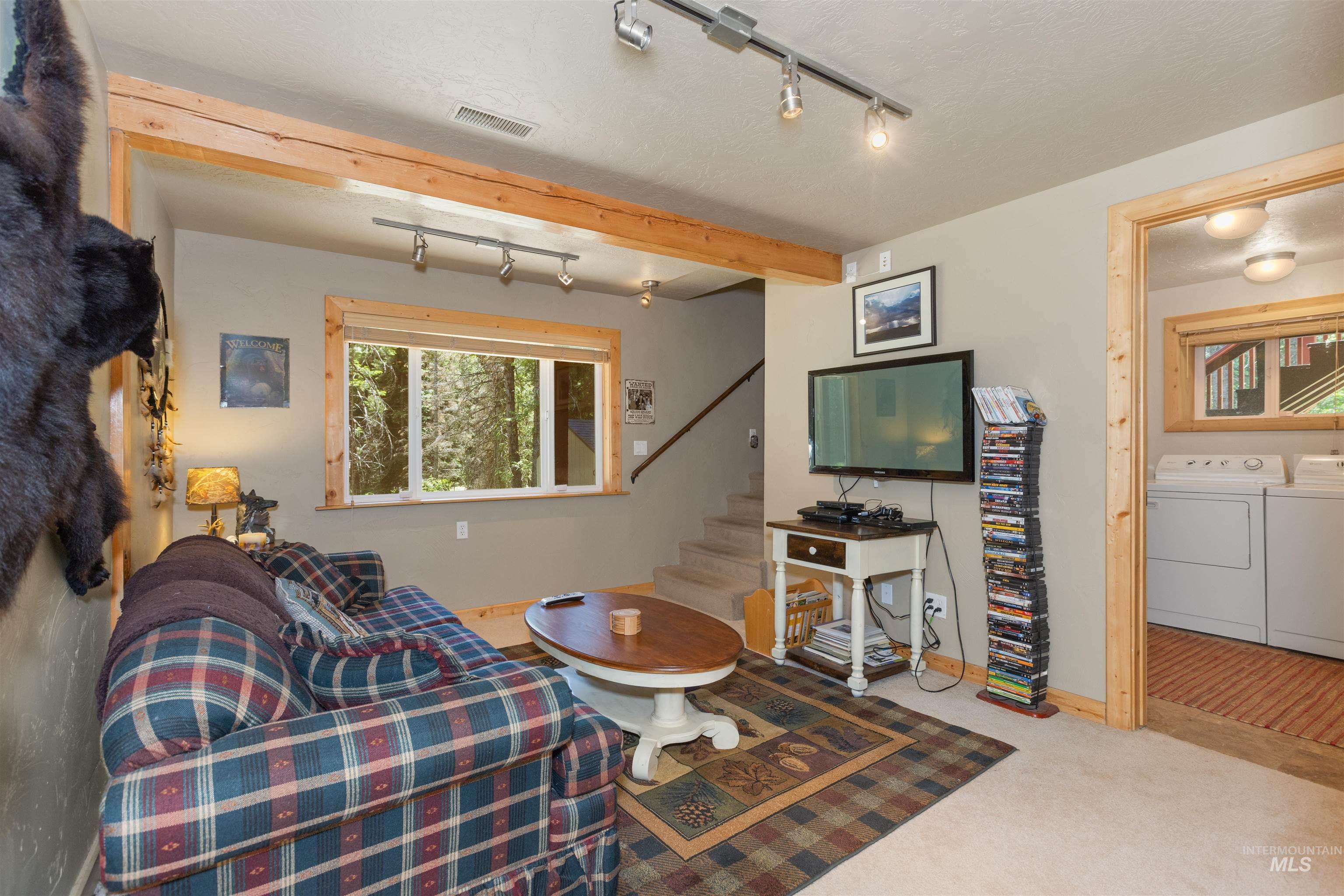1 Miller Lane Cascade, ID 83611 - Photo 19 of 39 Living area featuring washing machine and dryer, rail lighting, stairs, and carpet