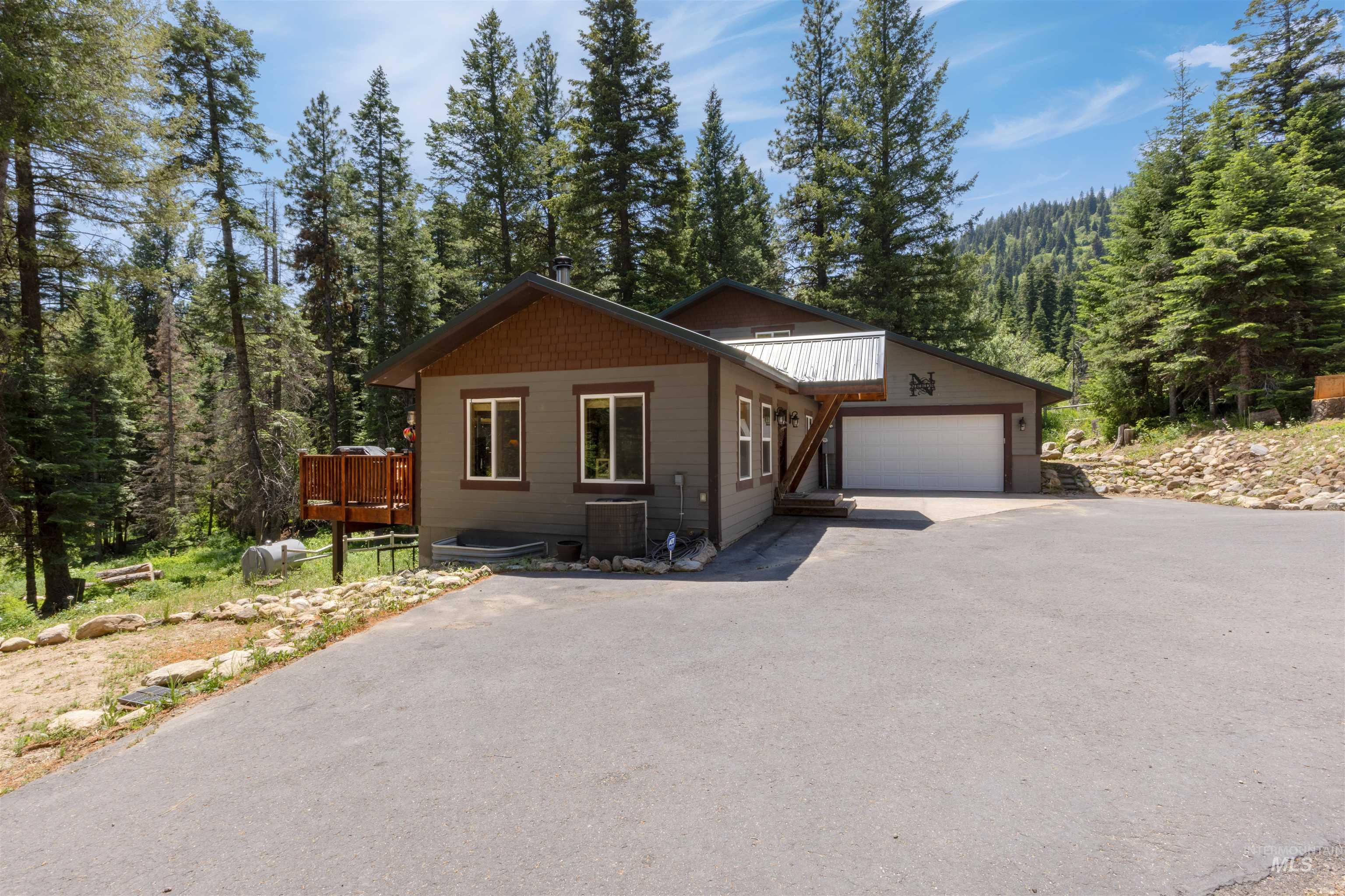 1 Miller Lane Cascade, ID 83611 - Photo 2 of 39 View of front of house with driveway, an attached garage, a forest view, and a deck