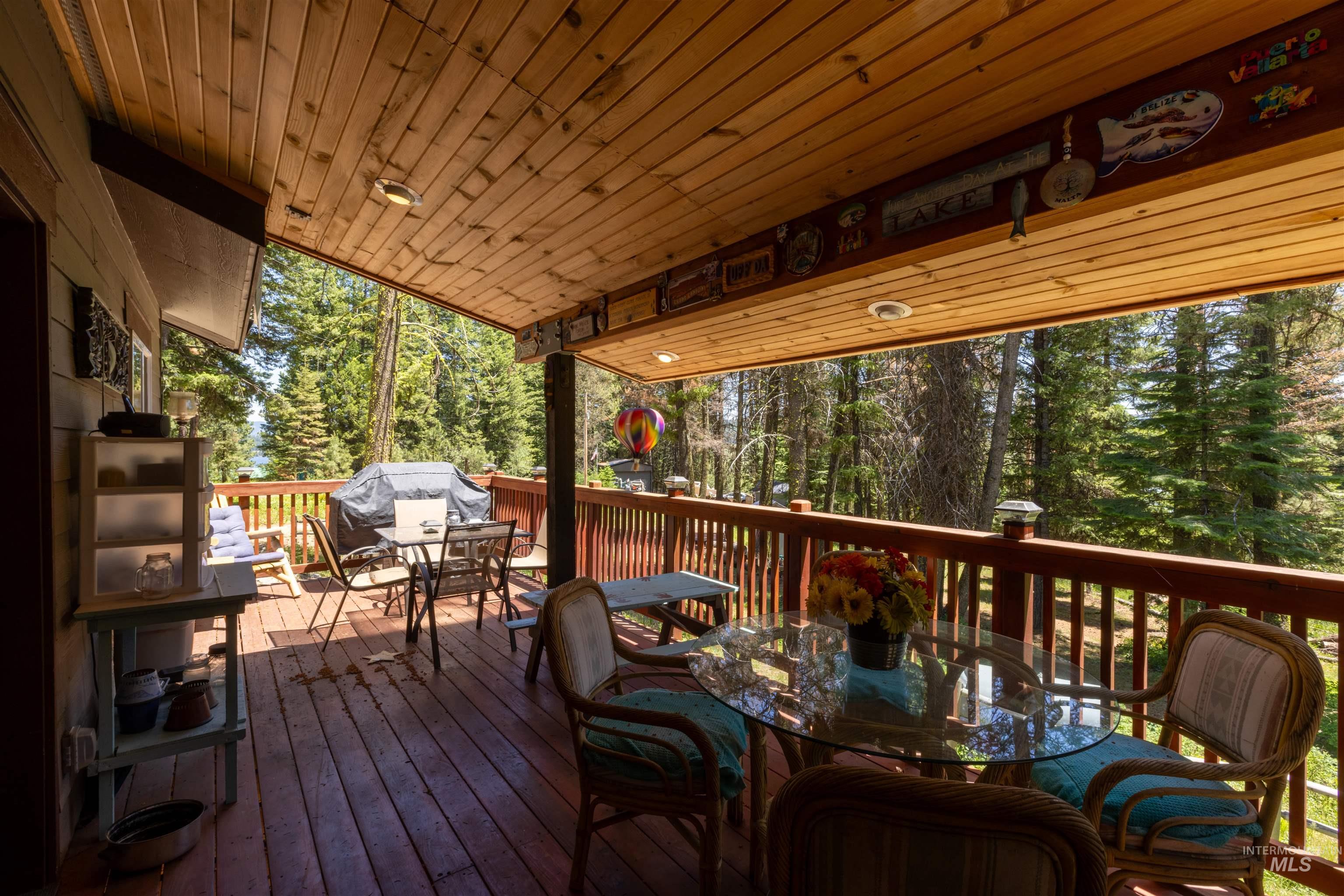 1 Miller Lane Cascade, ID 83611 - Photo 28 of 39 Wooden deck featuring outdoor dining space, grilling area, and view of scattered trees