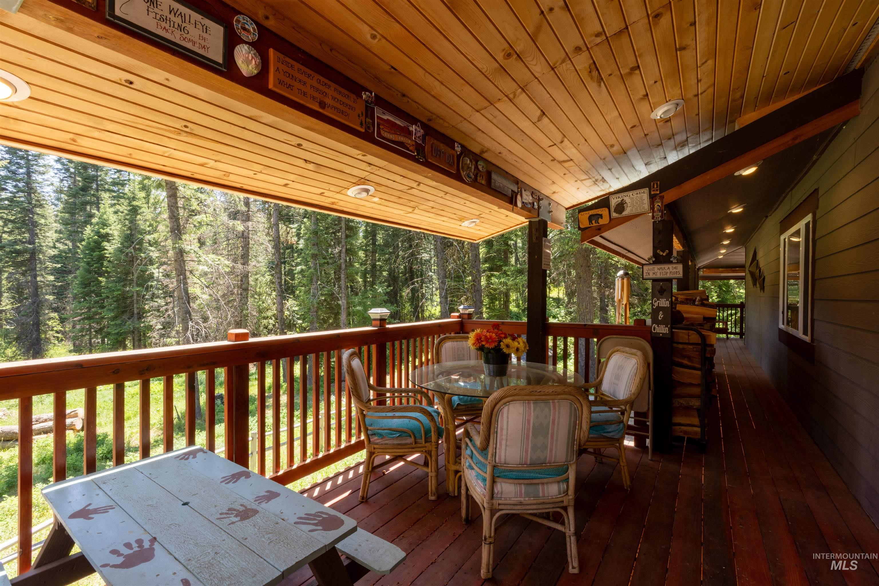 1 Miller Lane Cascade, ID 83611 - Photo 29 of 39 Wooden deck with outdoor dining space and a view of trees