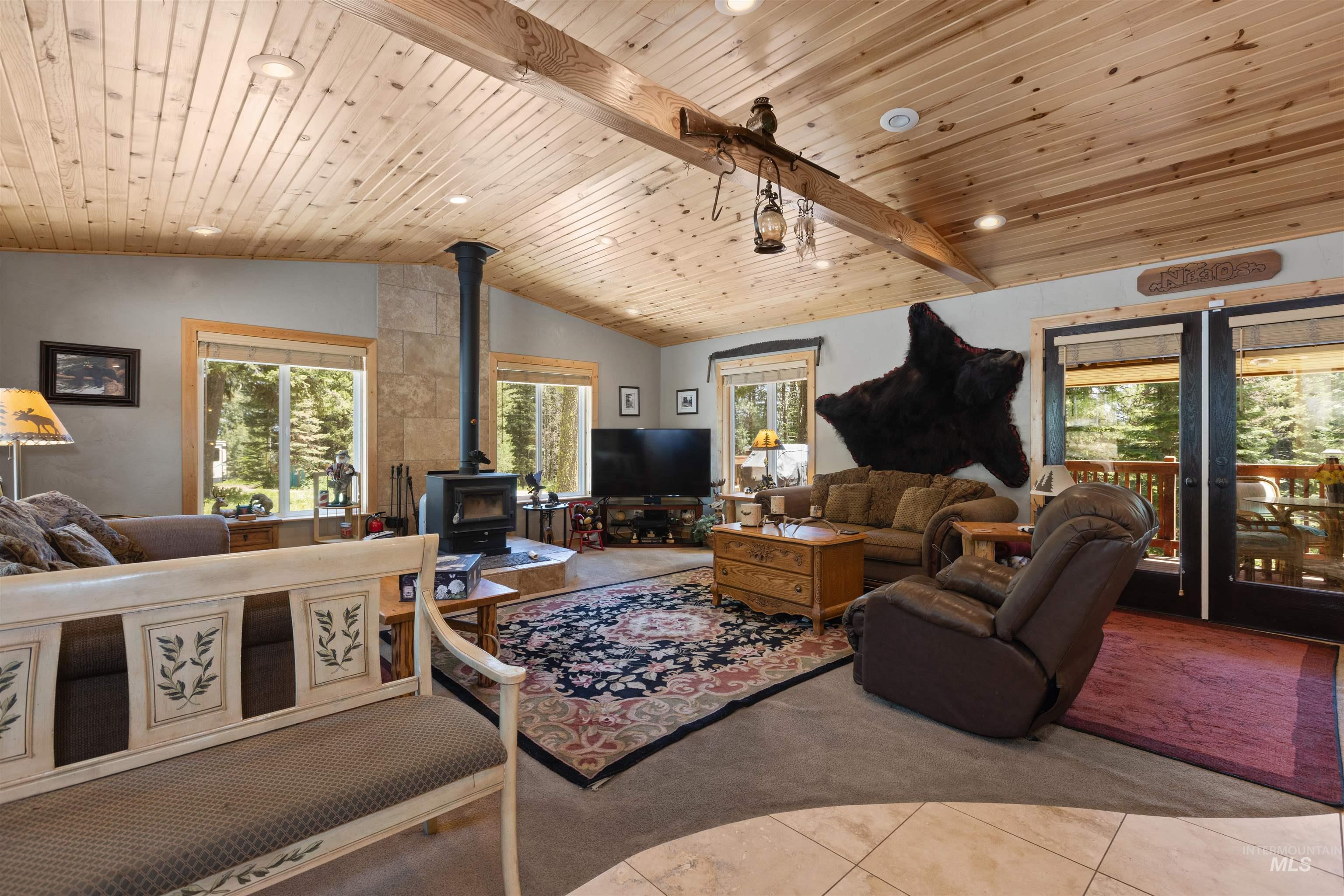1 Miller Lane Cascade, ID 83611 - Photo 3 of 39 Tiled living area with carpet floors, a wood stove, vaulted ceiling, wooden ceiling, and recessed lighting