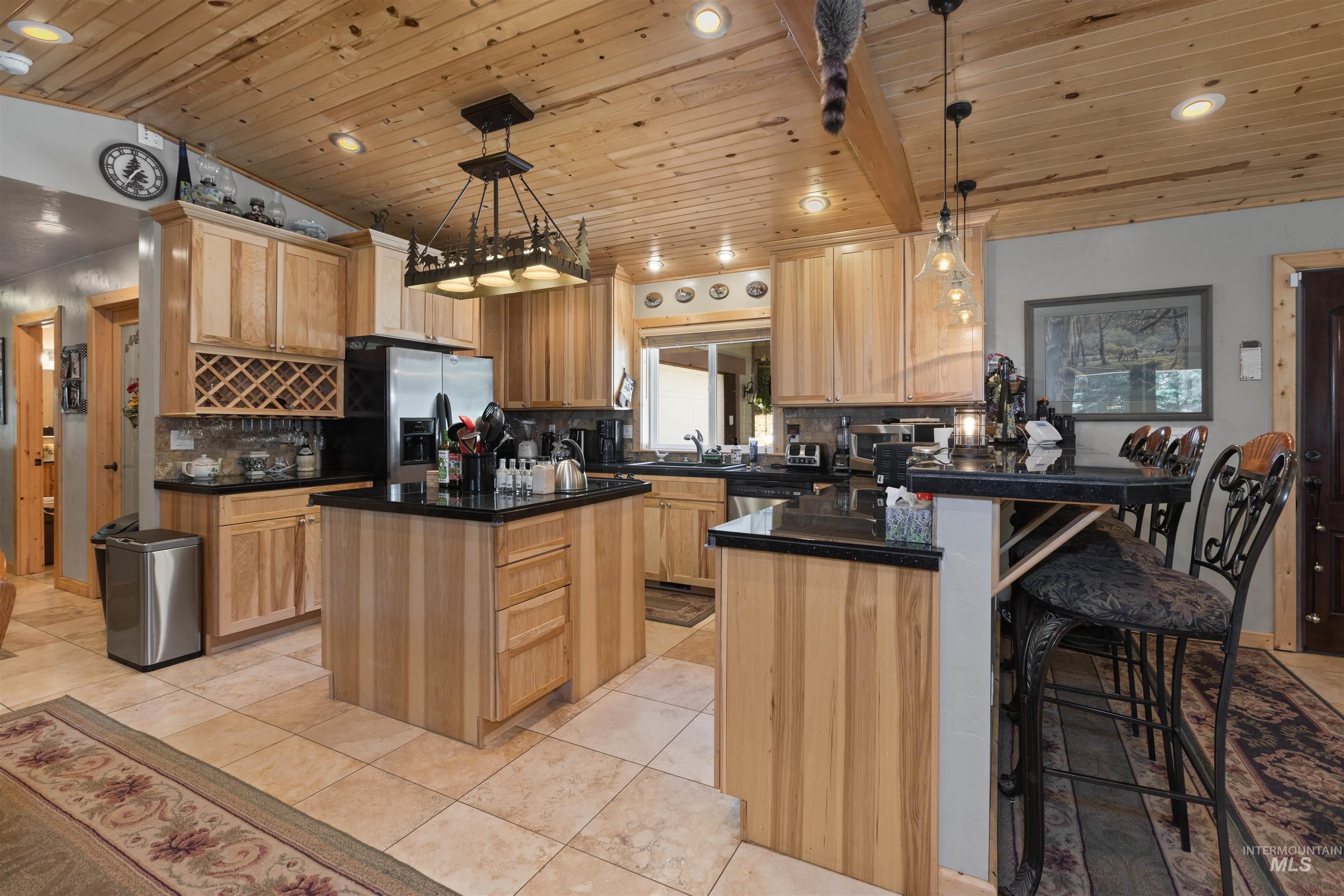1 Miller Lane Cascade, ID 83611 - Photo 10 of 39 Kitchen featuring wooden ceiling, stainless steel fridge with ice dispenser, a peninsula, light brown cabinetry, and backsplash