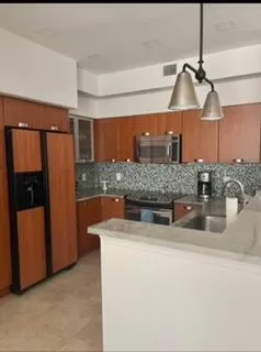 a kitchen with stainless steel appliances granite countertop a sink and a refrigerator