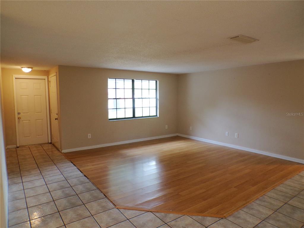 1123 Foggy Ridge Parkway Lutz, FL 33559 - Photo 7 of 18 an empty room with wooden floor and windows