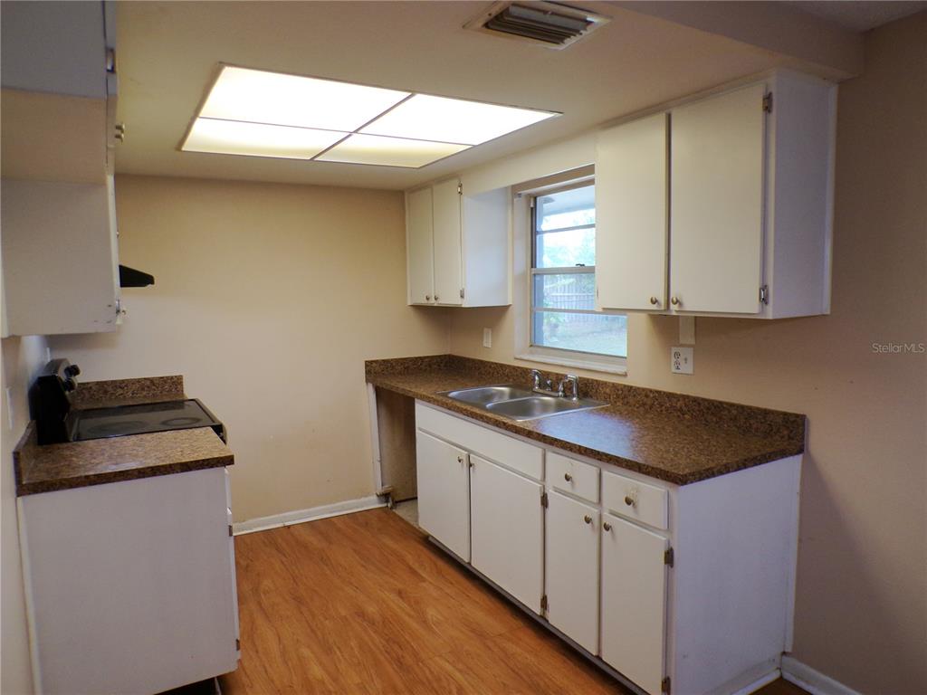 1123 Foggy Ridge Parkway Lutz, FL 33559 - Photo 8 of 18 a kitchen with sink stove and cabinets