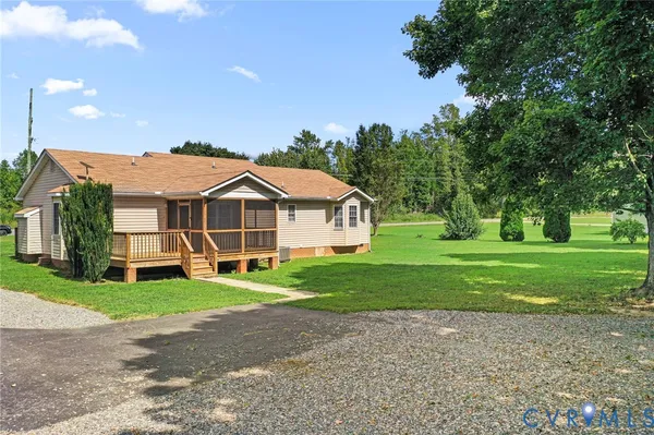 a view of a house with a big yard and large trees