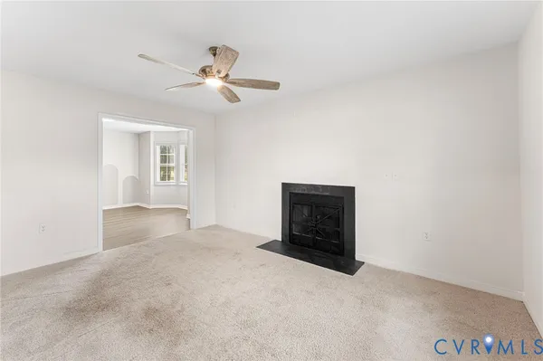 an empty room with windows and ceiling fan