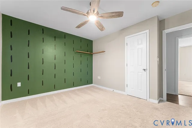 a view of a big room with closet and a ceiling fan