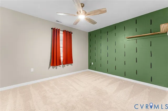 a view of an empty room with window and fan
