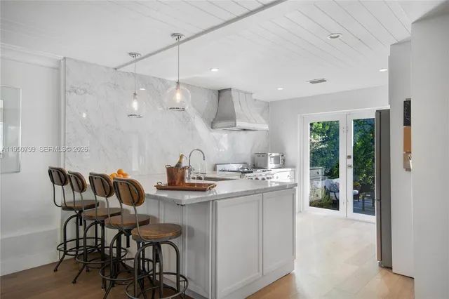 a kitchen with granite countertop a sink and chairs