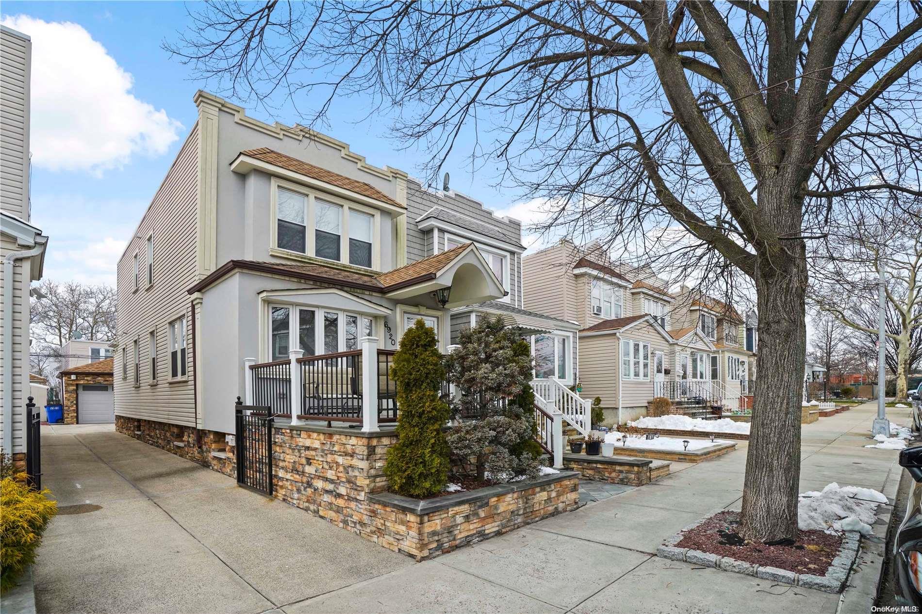 69-20 68th Street Queens, NY 11385 - Photo 1 of 1 a view of a white house with large tree and wooden fence