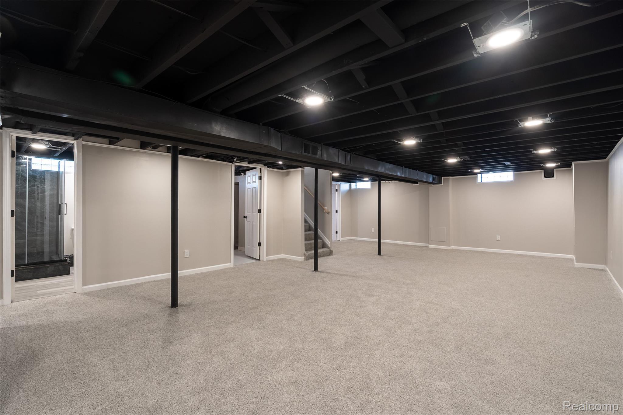 201 Cardwell Street Inkster, MI 48141 - Photo 32 of 41 Finished basement space featuring light gray carpeting, neutral-toned walls, and a black open-joist ceiling with recessed lighting