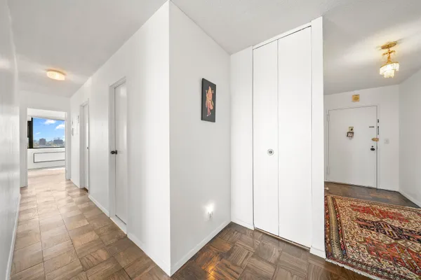 a view of a hallway with bathroom and wooden floor