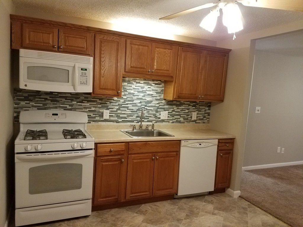 549 Pine Street, Unit 1 Lowell, MA 01851 - Photo 2 of 12 a kitchen with sink a microwave and cabinets