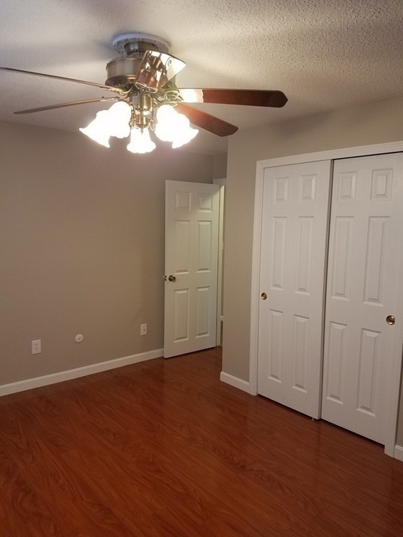 549 Pine Street, Unit 1 Lowell, MA 01851 - Photo 6 of 12 a view of an empty room with wooden floor and a window