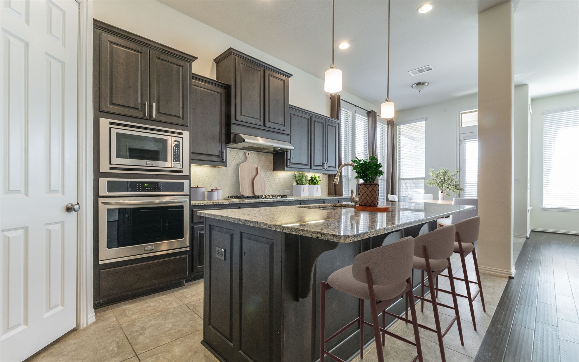 3815 Ashbury Road Round Rock, TX 78681 - Photo 1 of 1 Kitchen with appliances with stainless steel finishes, under cabinet range hood, a sink, a breakfast bar, and healthy amount of natural light