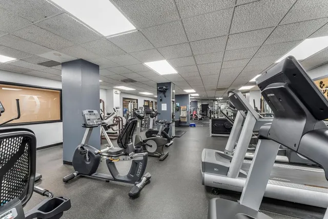 a gym room with lots of furniture and white walls