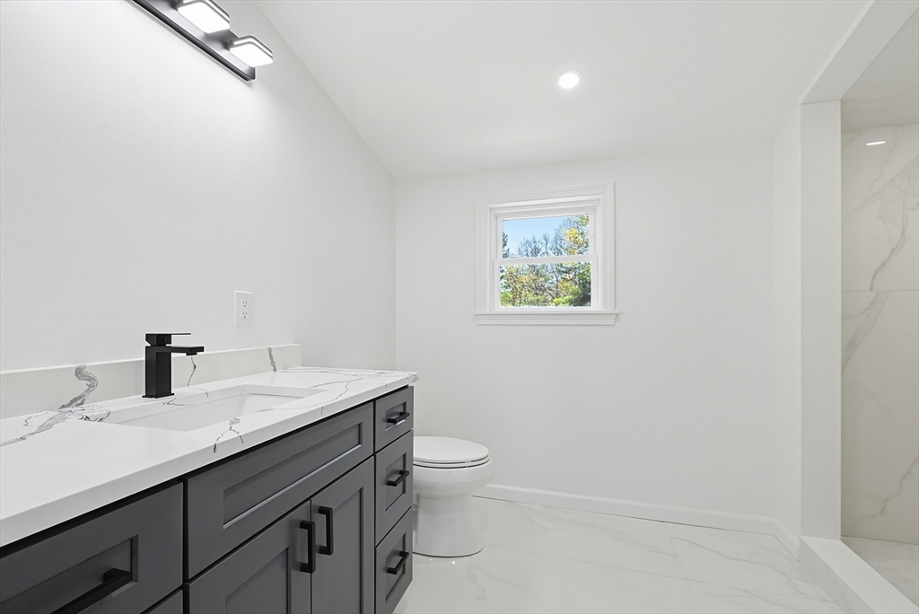 175 Pleasant Street Upton, MA 01568 - Photo 31 of 39 a bathroom with a granite countertop sink a toilet and a mirror