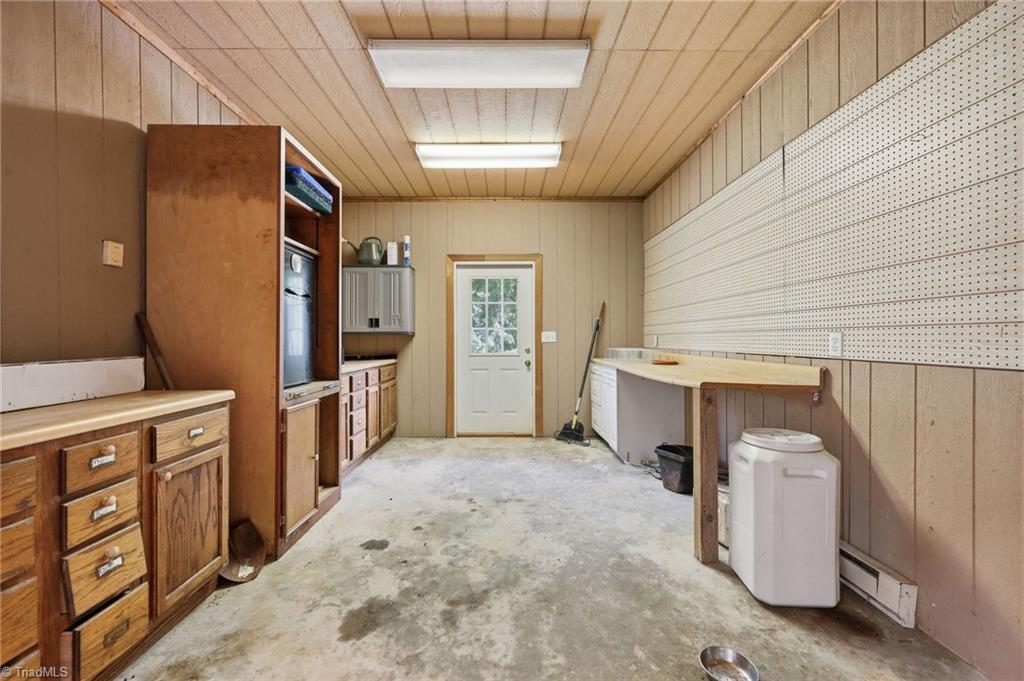 8861 Boylston Road Colfax, NC 27235 - Photo 48 of 50 Heated workshop with built-in cabinetry, generous workspace, and dedicated hot water—ideal for projects, equipment maintenance, or hobby use.