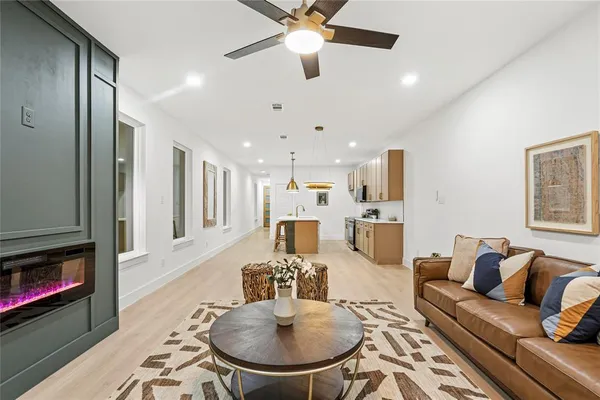 a living room with furniture kitchen view and a fireplace
