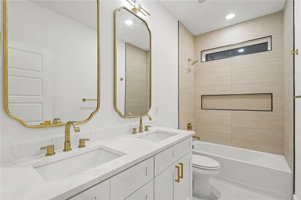 a bathroom with a double vanity sink toilet mirror and shower