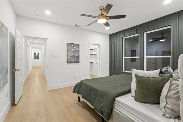 a spacious bedroom with a bed and ceiling fan