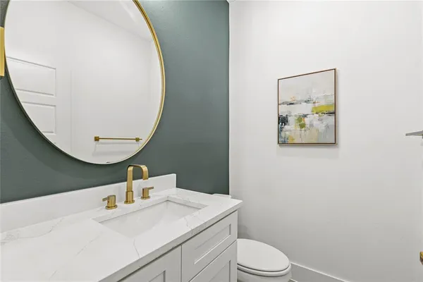 a bathroom with a sink mirror vanity and toilet