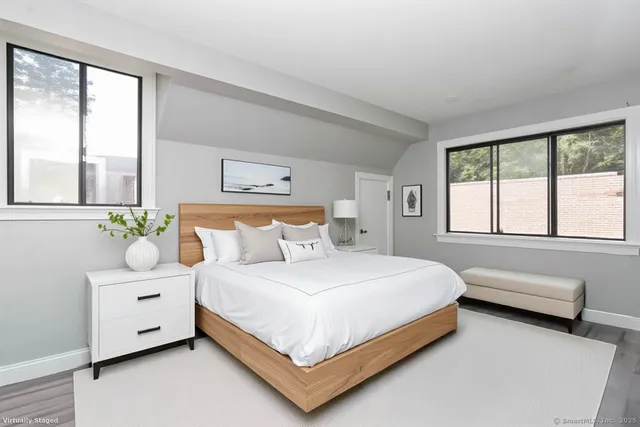 a bedroom with a bed and a large window