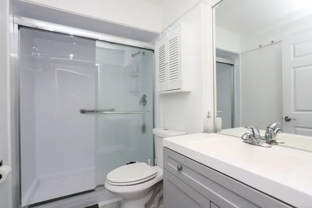 a bathroom with a sink a toilet and shower