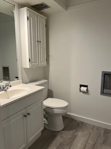 a bathroom with a toilet sink and mirror