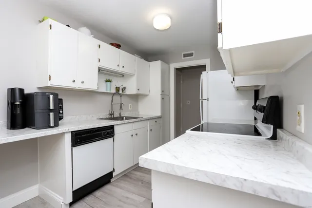 a kitchen with stainless steel appliances a sink a stove a refrigerator and cabinets