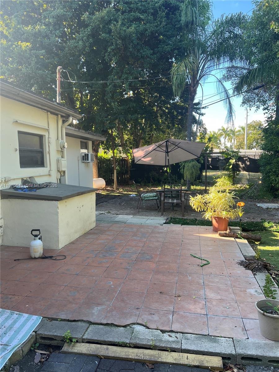 14435 Southwest 289th Street Homestead, FL 33033 - Photo 16 of 18 a view of a patio with table and chairs under an umbrella