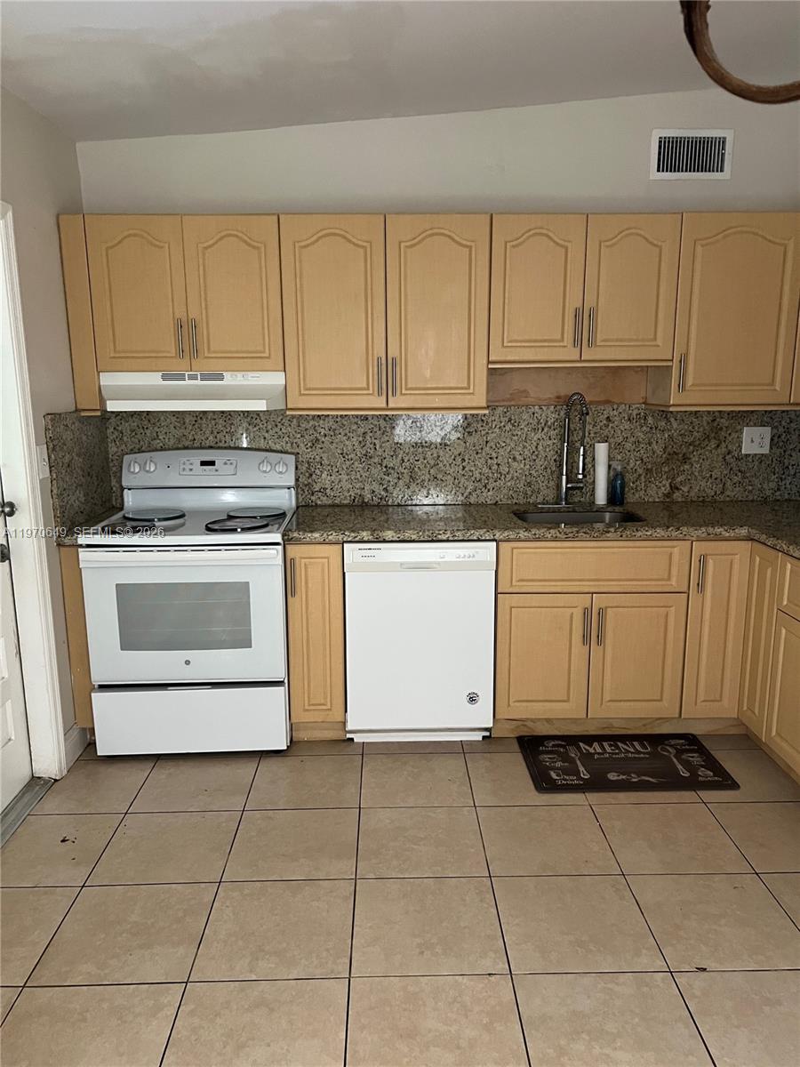 14435 Southwest 289th Street Homestead, FL 33033 - Photo 6 of 18 a kitchen with a stove top oven microwave and cabinets