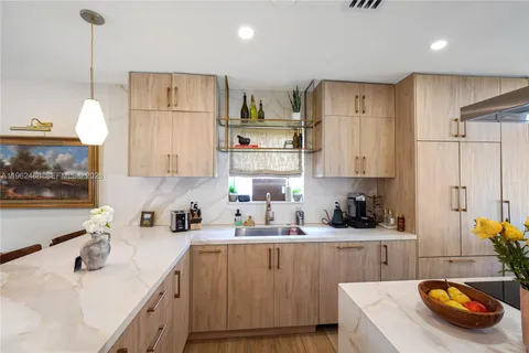 a kitchen with stainless steel appliances a sink a stove a refrigerator and cabinets