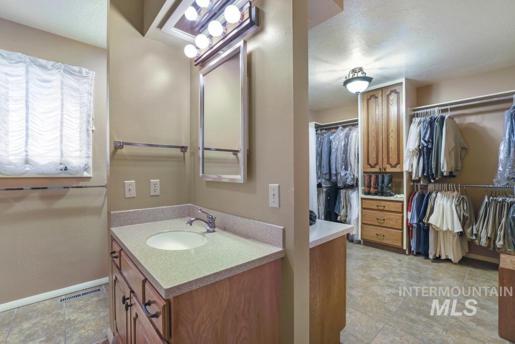 2018 Rancho Vista Drive Twin Falls, ID 83301 - Photo 23 of 50 Vanity with an integrated sink, light-toned countertop, and wood-finish cabinetry