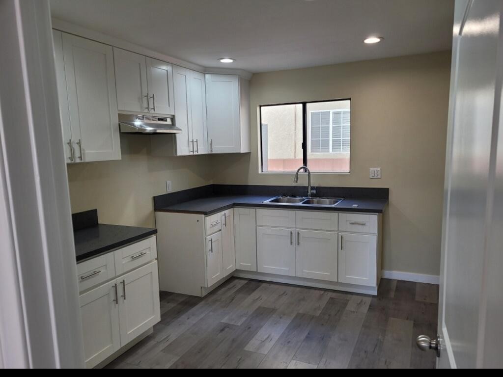 a kitchen with granite countertop white cabinets white appliances and granite counter tops