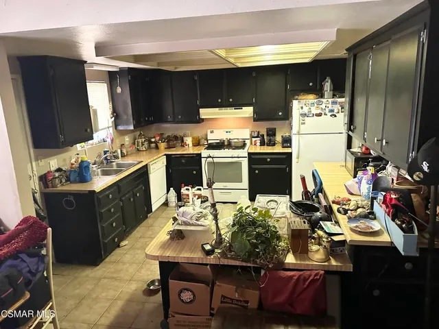 a kitchen with kitchen island granite countertop a sink appliances and cabinets