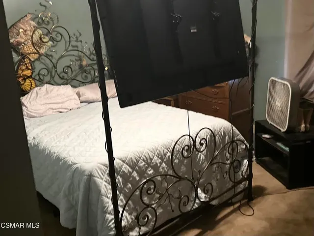 a bed sitting in a bedroom next to a window