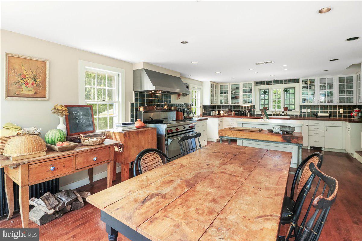 920 Cherry Valley Road Princeton, NJ 08540 - Photo 16 of 58 a large kitchen with kitchen island a stove a sink dishwasher a dining table and chair with wooden cabinets