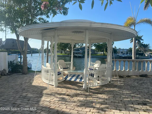 a view of a patio with a dining table and chairs under an umbrella