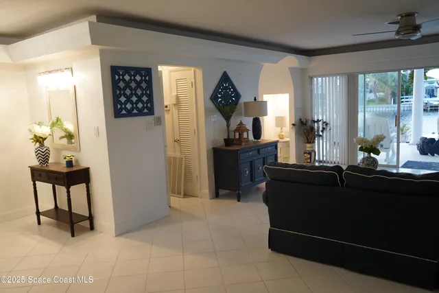 a living room with furniture a large window and a chandelier