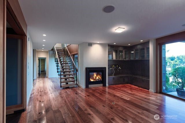 630 Harrison Street Friday Harbor, WA 98250 - Photo 19 of 37 an empty room with wooden floor fireplace and staircase