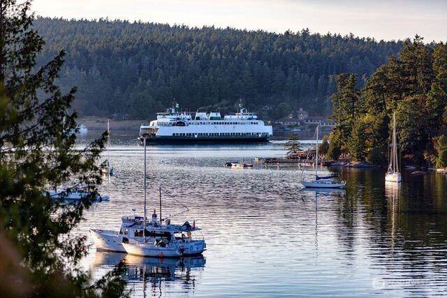 630 Harrison Street Friday Harbor, WA 98250 - Photo 7 of 37 a view of a lake with mountain view and a floor to ceiling window