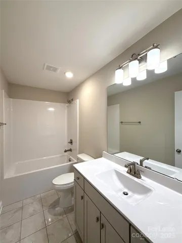 a bathroom with a sink a toilet and a large mirror