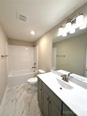 a bathroom with a double vanity sink mirror and toilet