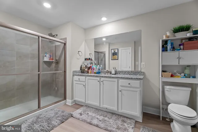 a bathroom with a granite countertop sink toilet and shower