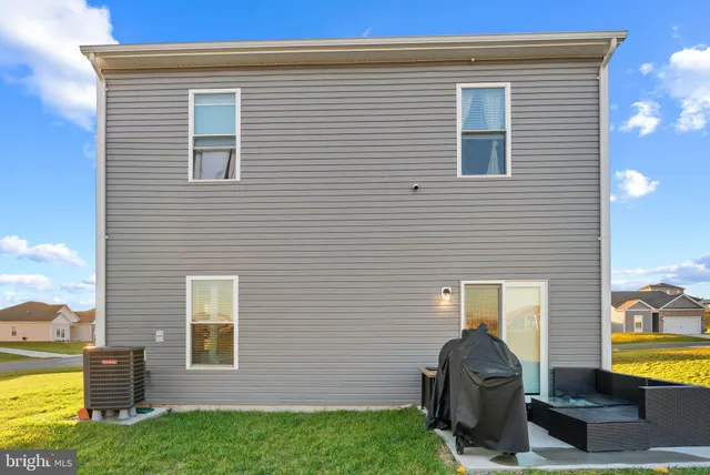 a view of backyard with barbeque grill and wooden fence